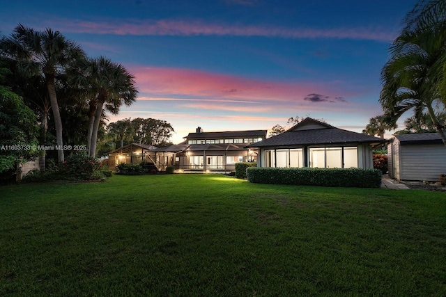 back house at dusk with a yard