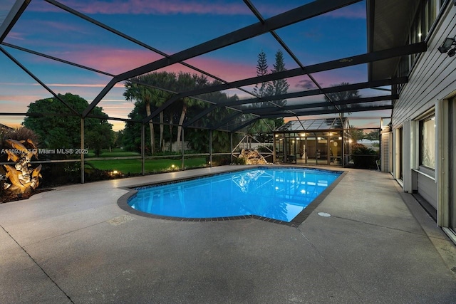 pool at dusk with a lanai and a patio