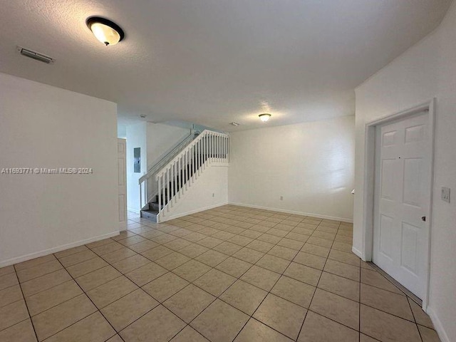 tiled spare room with a textured ceiling