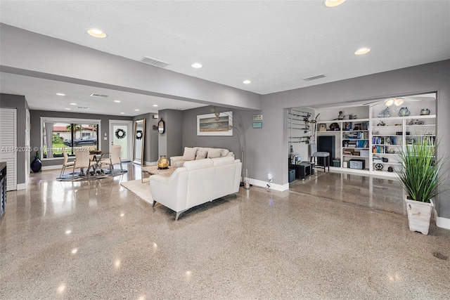 living room featuring ceiling fan and a textured ceiling