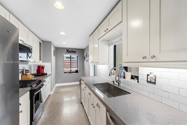 kitchen with sink, white cabinetry, stainless steel appliances, and tasteful backsplash