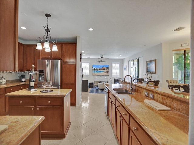 kitchen with appliances with stainless steel finishes, ceiling fan, sink, pendant lighting, and light tile patterned flooring