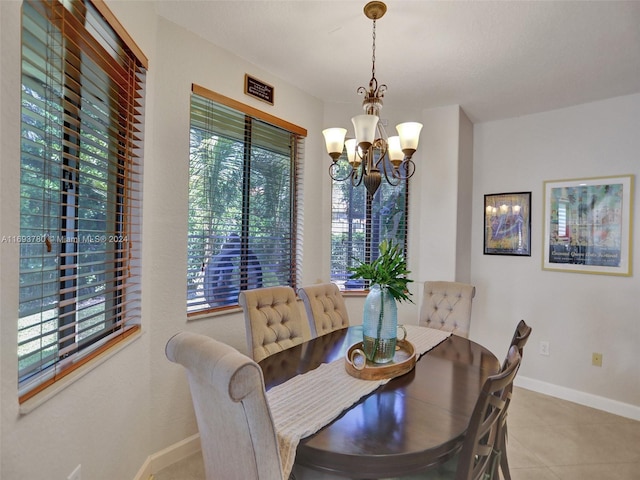 dining area with light tile patterned floors and an inviting chandelier