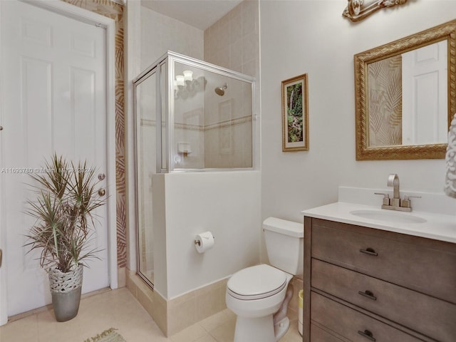 bathroom with toilet, vanity, tile patterned floors, and an enclosed shower