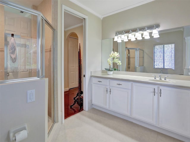 bathroom featuring vanity, tile patterned floors, a shower with door, and crown molding