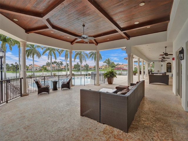 view of patio with ceiling fan and a water view