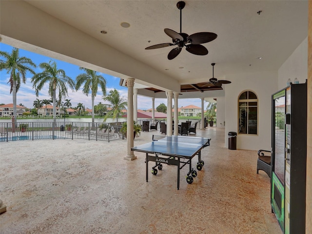 view of patio with a water view and ceiling fan