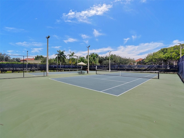 view of tennis court featuring basketball hoop