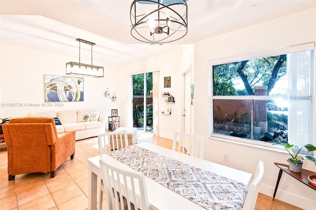 tiled dining room with a notable chandelier