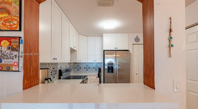 kitchen featuring kitchen peninsula, white cabinets, appliances with stainless steel finishes, and tasteful backsplash