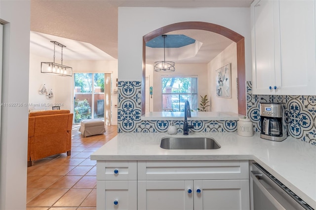 kitchen featuring white cabinets, pendant lighting, a healthy amount of sunlight, and sink