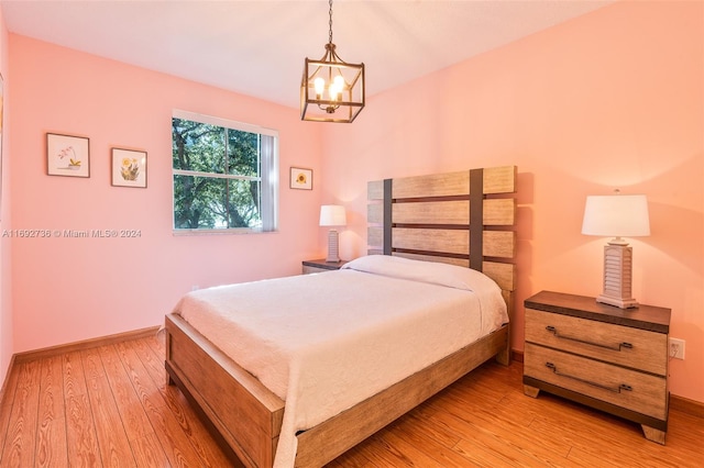 bedroom with a notable chandelier and light hardwood / wood-style floors