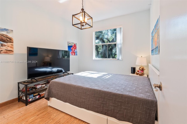 bedroom with a chandelier and hardwood / wood-style flooring