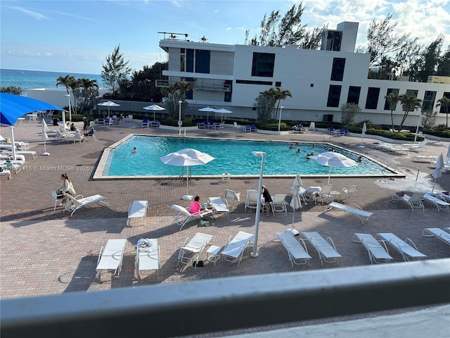 view of swimming pool with a water view and a patio