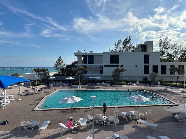 view of pool featuring a patio and a water view