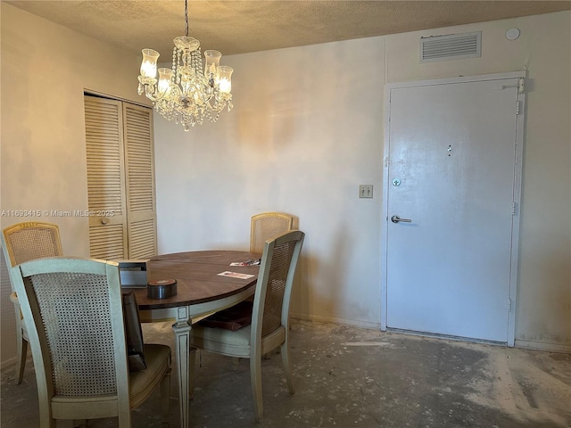 dining space with an inviting chandelier, concrete flooring, and a textured ceiling