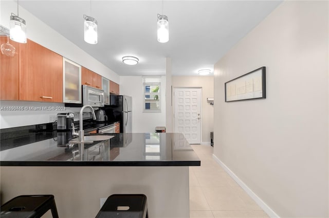 kitchen featuring a kitchen breakfast bar, stainless steel appliances, and pendant lighting