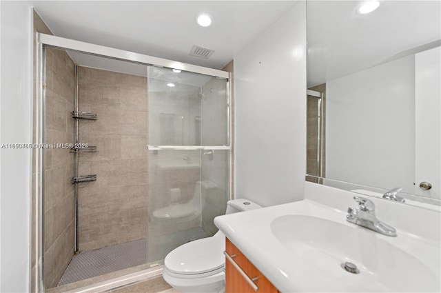 bathroom with an enclosed shower, vanity, and toilet