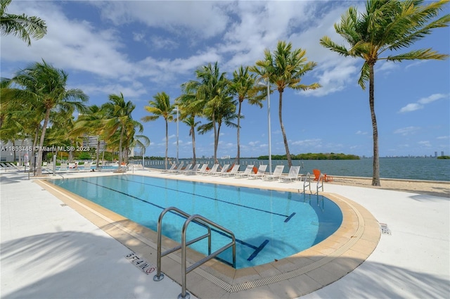 view of pool with a patio area and a water view