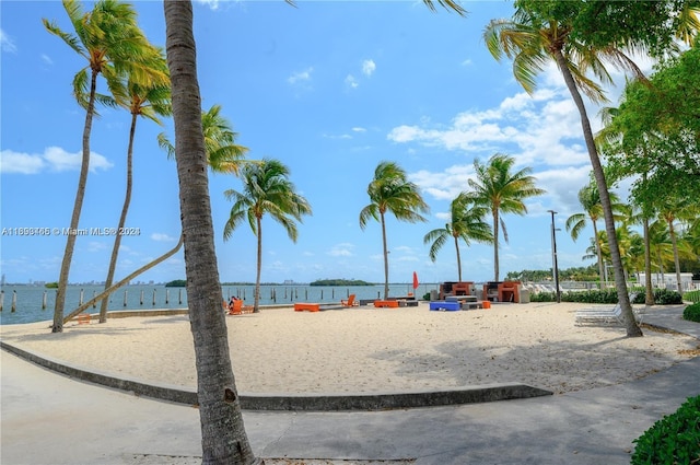 view of playground featuring a beach view and a water view