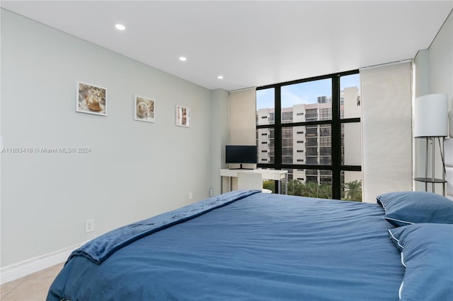 bedroom with expansive windows and light tile patterned floors