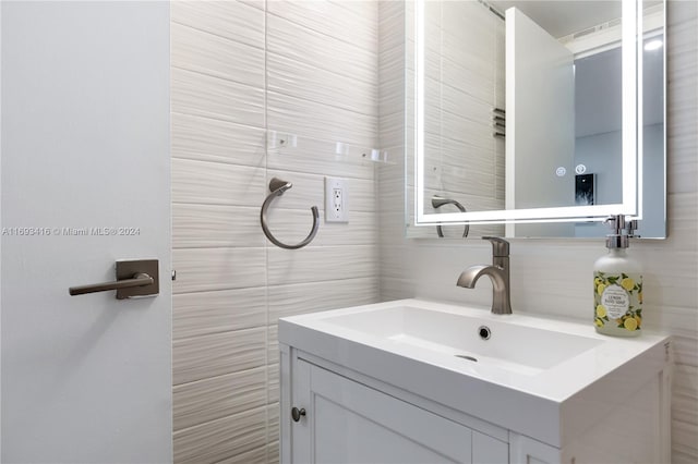 bathroom with vanity and tile walls