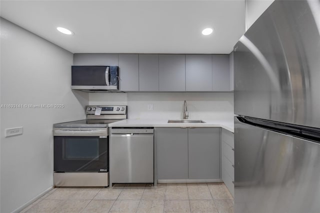 kitchen featuring appliances with stainless steel finishes, gray cabinets, sink, and light tile patterned floors