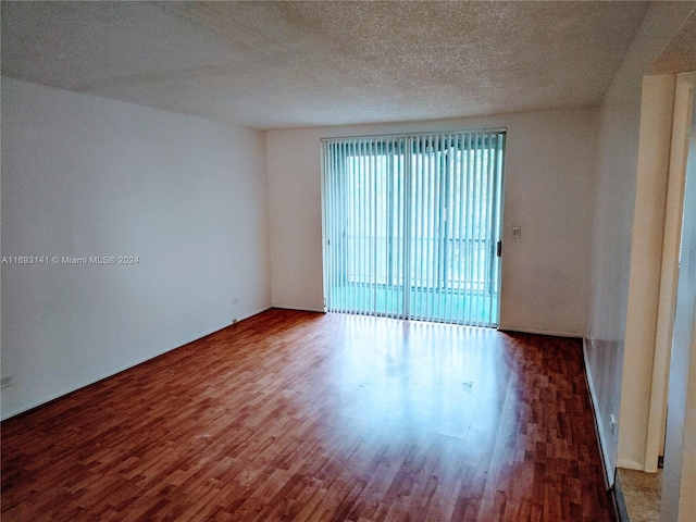 spare room with hardwood / wood-style floors and a textured ceiling