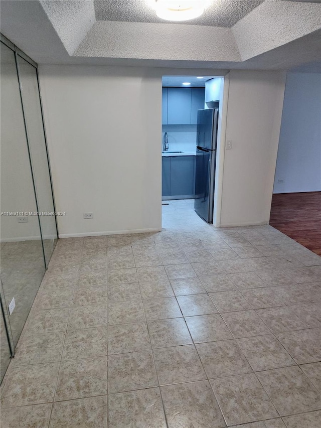 spare room with a textured ceiling, light hardwood / wood-style floors, and sink