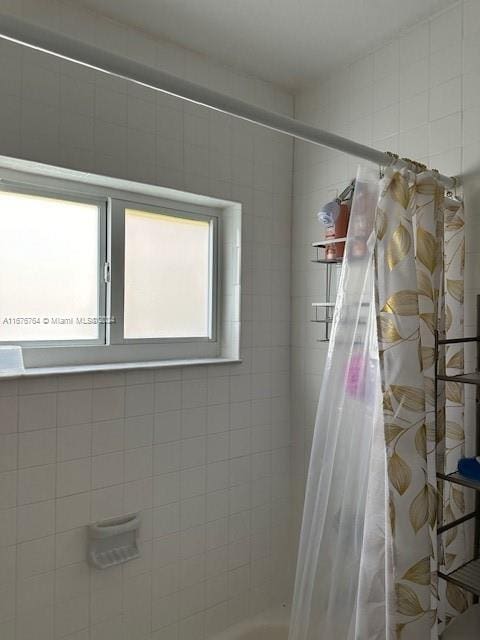 bathroom featuring plenty of natural light and curtained shower