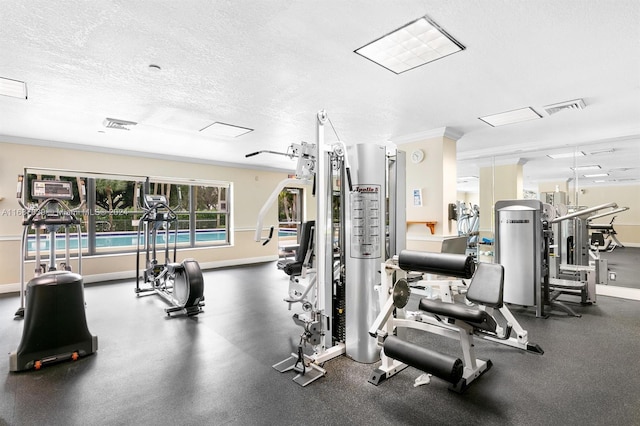 exercise room with crown molding and a textured ceiling