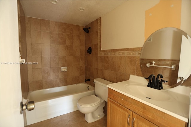 full bathroom featuring vanity, tile patterned flooring, tiled shower / bath combo, toilet, and tile walls