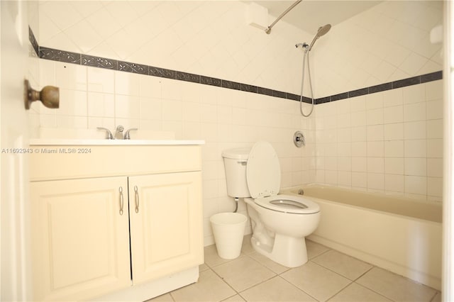 full bathroom with vanity, tile patterned flooring, tiled shower / bath combo, toilet, and tile walls