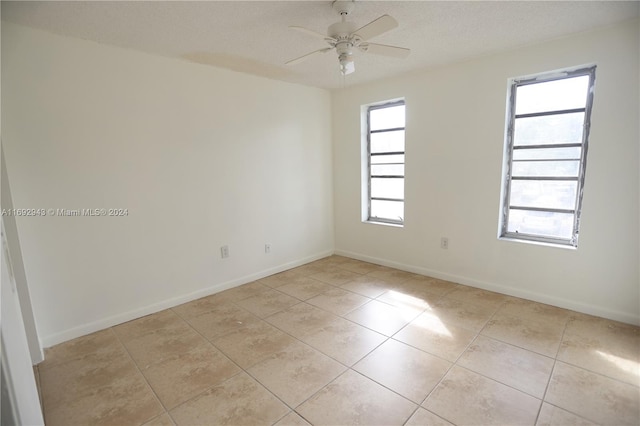 tiled spare room with ceiling fan and a textured ceiling