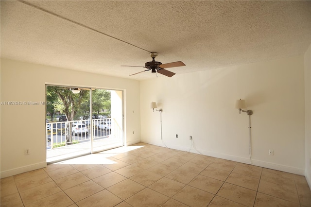 tiled empty room with ceiling fan and a textured ceiling