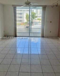 tiled spare room with ceiling fan