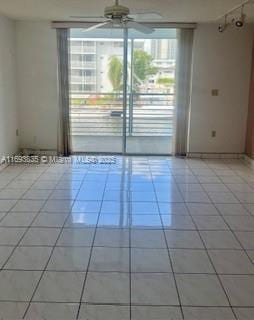 spare room with light tile patterned floors and a ceiling fan