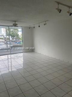 spare room featuring ceiling fan and light tile patterned flooring