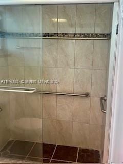 full bathroom with tile patterned flooring and a stall shower
