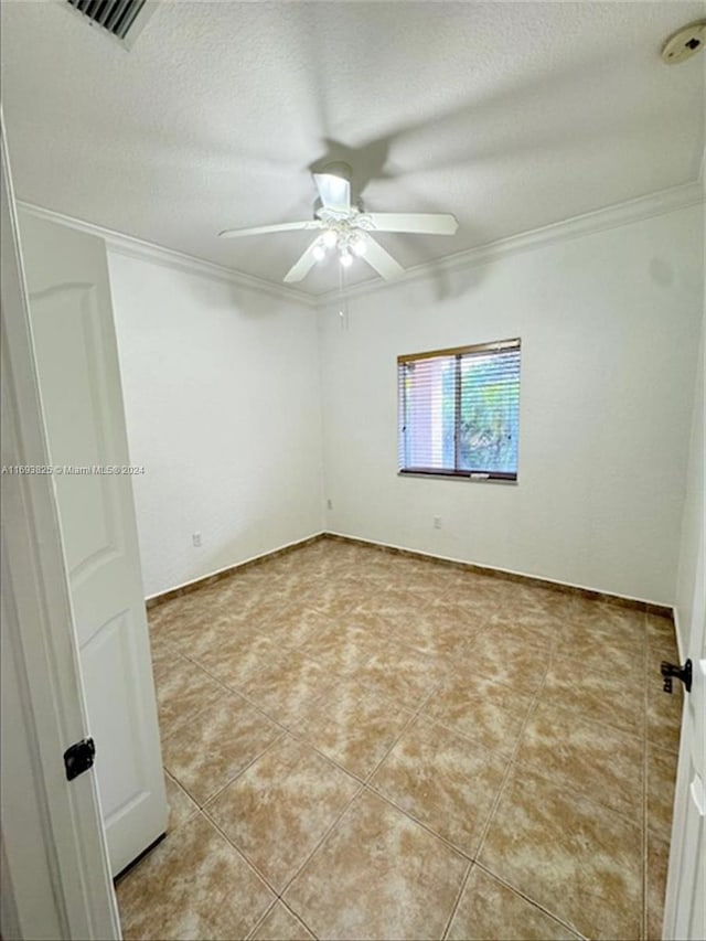 tiled empty room featuring crown molding, ceiling fan, and a textured ceiling