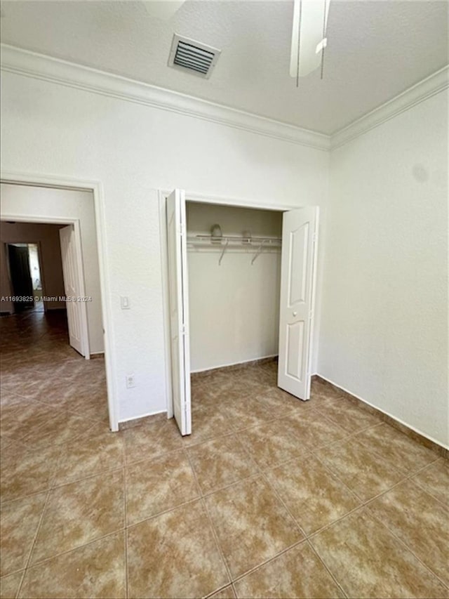 unfurnished bedroom with a closet and ornamental molding