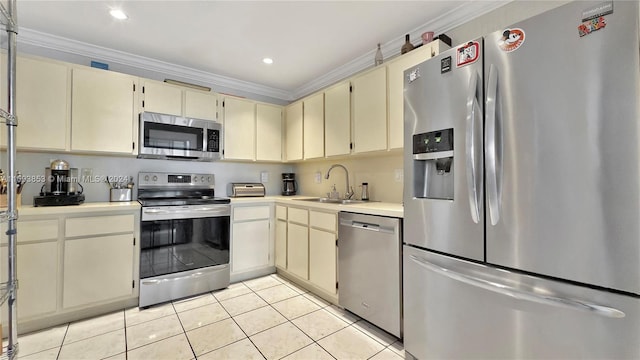 kitchen with cream cabinets, stainless steel appliances, ornamental molding, and sink