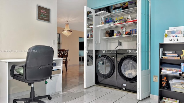 laundry area featuring washing machine and dryer, light tile patterned flooring, and a chandelier