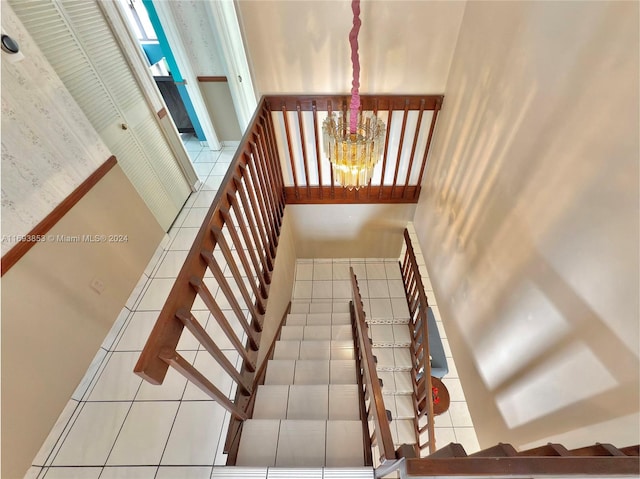 staircase featuring a chandelier and tile patterned floors