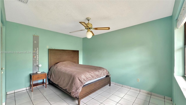 tiled bedroom featuring ceiling fan and a textured ceiling