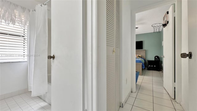 bathroom with tile patterned floors, a textured ceiling, and shower / tub combo