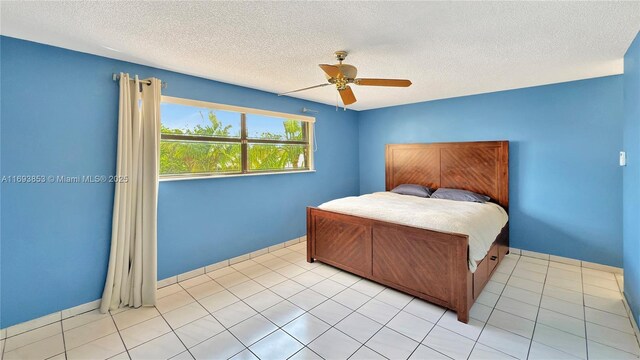 tiled bedroom with a textured ceiling and ceiling fan