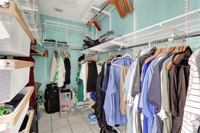 walk in closet with light tile patterned floors