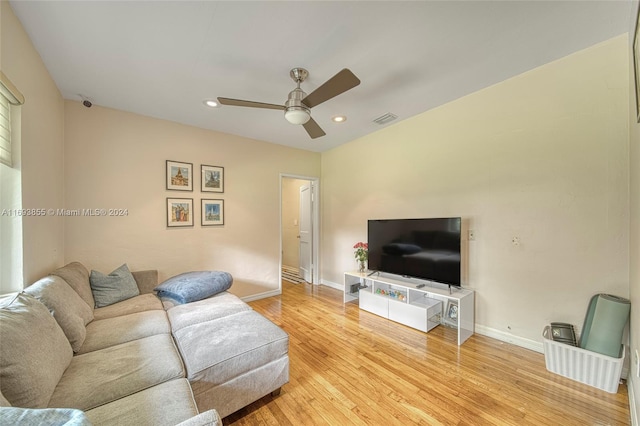 living room featuring light hardwood / wood-style flooring and ceiling fan