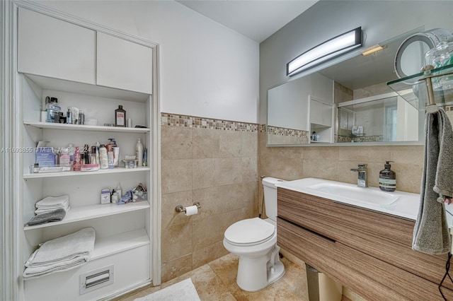 bathroom featuring tile patterned flooring, vanity, tile walls, and toilet